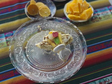 Pieces of brownies on a crystal vase and fruits, overhead close-up shot
