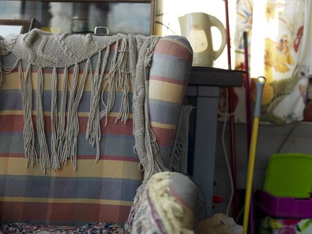 Cluttered closet with old armchair in the foreground