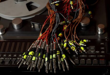 Bunch of audio cables on a reel-to-reel tape recorder, indoor close-up shot