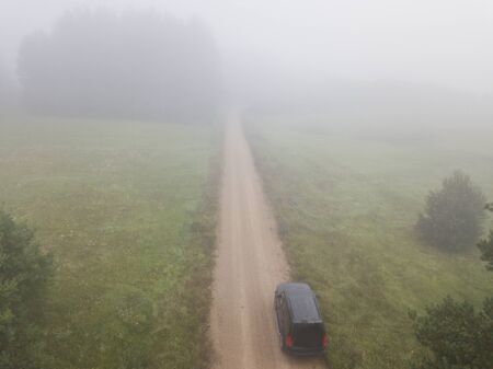 Overhead view of a car driving in morning fogの写真素材