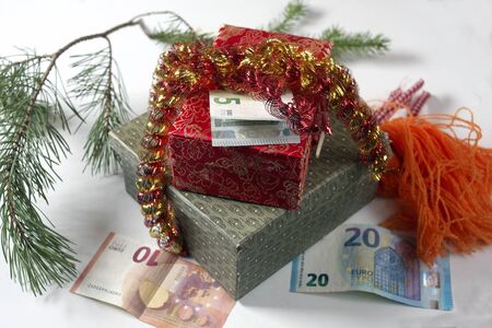 European currency and colorful gift box wrapped with tinsel, studio close-upの写真素材