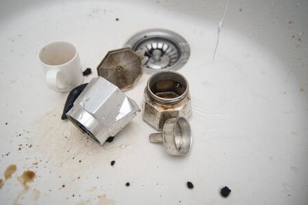Disassembled coffeemaker, dirty mug and stains on the surface of kitchen sinkの写真素材