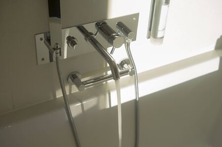 Modern bathroom interior with water running out of the tap