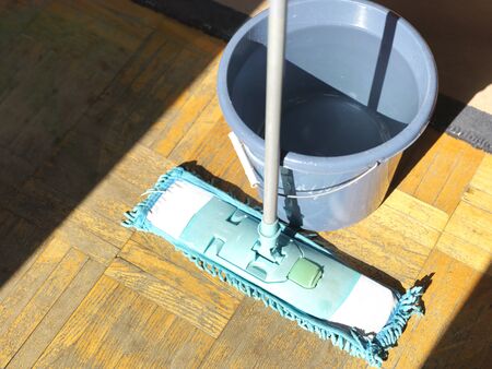 Closeup of a mop and bucket of clean water for room cleaning