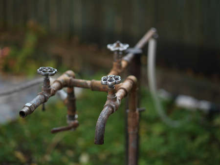 Old metal rusty water supply pipes and taps, shallow dofの写真素材