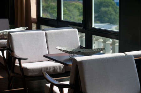 Dining room interior with a wide window, daytime shot
