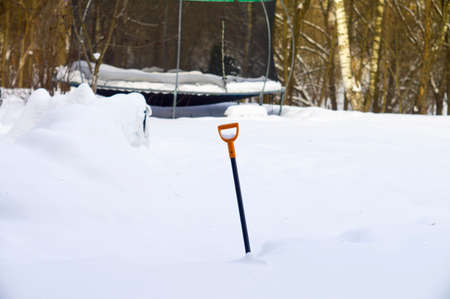 a shovel sticking out of the snow, winter sceneの写真素材