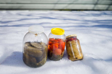 Vegetables in jars abandoned on the snow, outdoor shotの写真素材