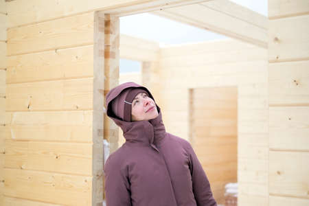 Young female dreaming about a new house to be finished, winter sceneの写真素材