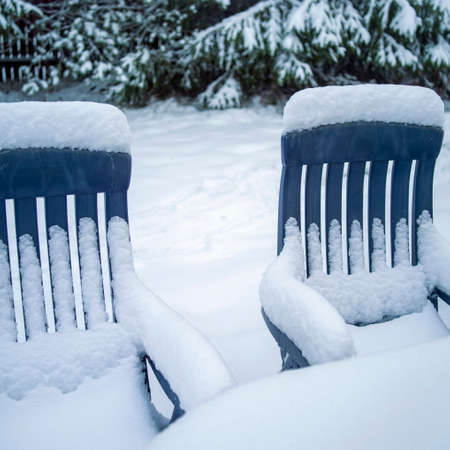 Garden furniture abandoned under snowfall, square composition, outdoor shotの写真素材