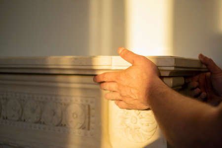 hands aligning a marble top for fireplace, sunny day indoor closeupの写真素材