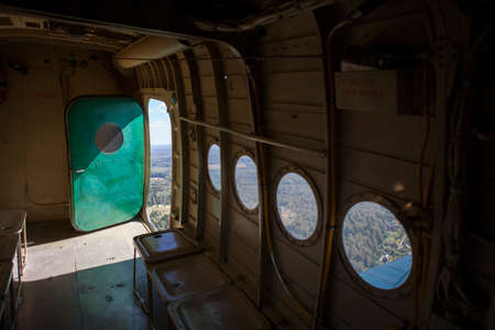 Open door and empty seats of old aircraft during a flightの写真素材