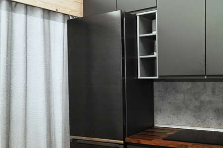 part of contemporary looking kitchen with a fridge next to a windowの写真素材