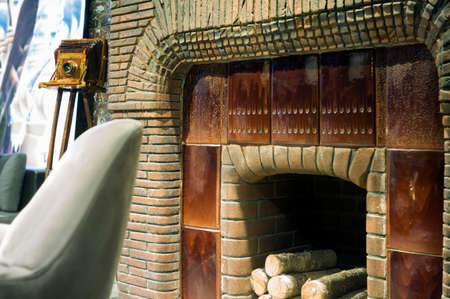 traditional red brick fireplace and retro photo camera in the background, indoor shotの写真素材