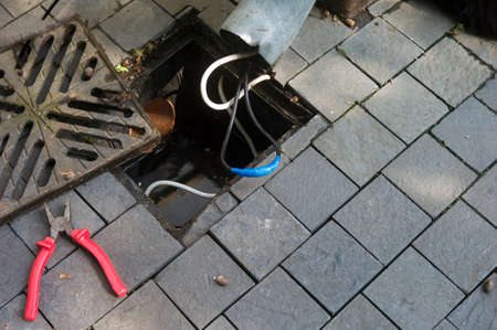 overflown storm drain and insulated wire after short circuit, outdoor shot