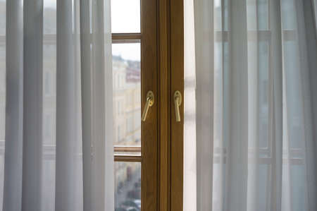 morning light through a window with half shot curtain
