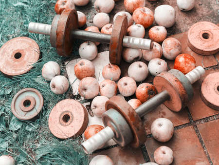 dumbbells and apples scattered on a ground, concept of healthy lifestyles,