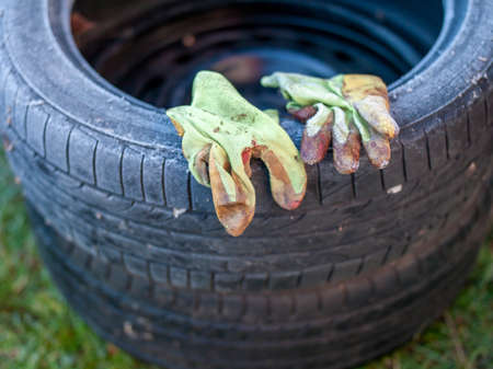 working gloves placed on tires, covered with ice, outdoor closeup, shallow DOFの写真素材