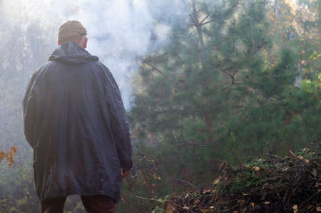 a man standing in a forest full of smoke, blurred outdoor imageの写真素材