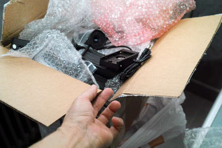 hand opened a cardboard box with abstract electronics, indoor closeupの写真素材