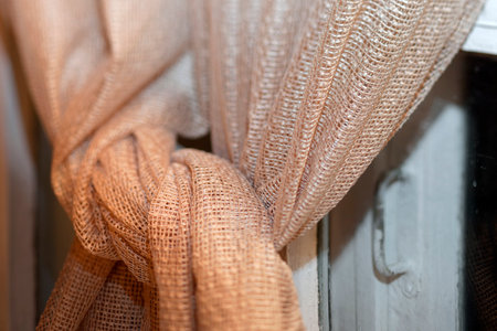 Shallow DOF shot of a knotted curtain on a window, night sceneの写真素材
