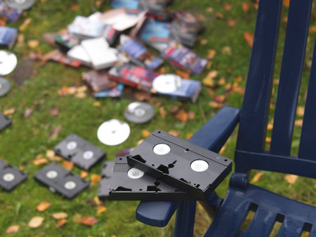 shallow dof shot of discarded video cassettes and compact discs outdoor