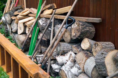 Chopped firewood and manual tools behind a barn, outdoor shotの写真素材