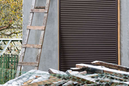 unfinished house protected with metal shutter on entrance doorの写真素材