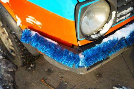 closeup of a car bumper, decorated with tinsel, outdoor shotの写真素材