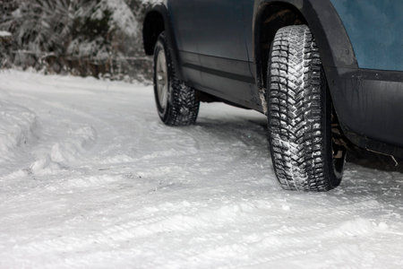 a car with winter tires turning on the snow, outdoor close up shotの写真素材
