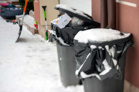 two full garbage containers on the street, winter sceneの写真素材