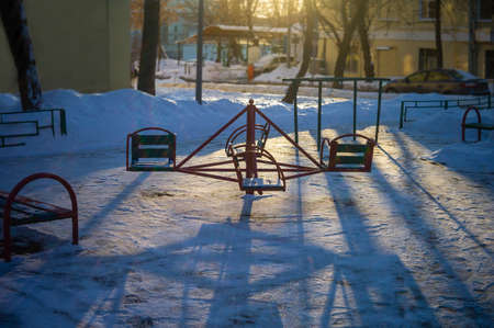 Abandoned playground with a carousel in the center of composition, winter sceneの写真素材