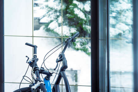 shallow DOF shot of two bikes in a storage room and a winter landscape behind a windowの写真素材