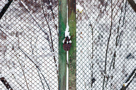 a rusty mesh and lock on outdoor gate, winyer sceneの写真素材