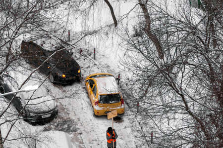 car accident on a slippery road and road worker with shovel, winter sceneの写真素材