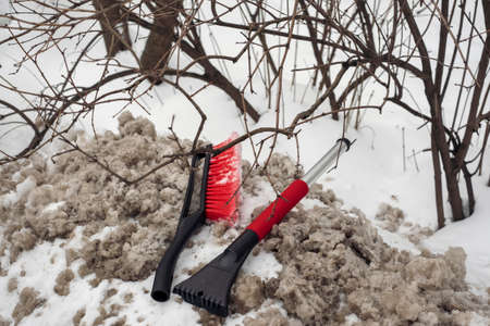 a broken car snow brush abandoned on a dirty snowdrift, outdoor closeupの写真素材