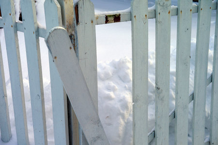 damaged wooden fence, concept of burglary, winter sceneの写真素材