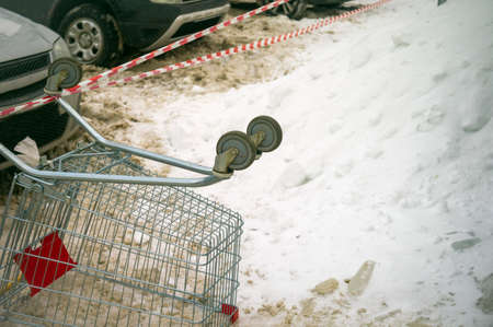 turned over shopping trolley and hazard tape, winter sceneの写真素材