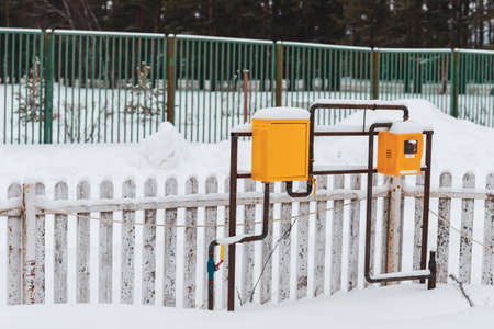 winter landscape with natural gas pipeline and yellow meter boxの写真素材
