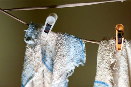 pinned shabby torn kitchen towels on a rope, indoor closeupの写真素材