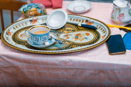 unfinished breakfast and mobile phone on a messy table, indoor shotの写真素材