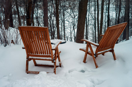 Two traditional wooden benches near a cliff to the river, winter sceneの写真素材