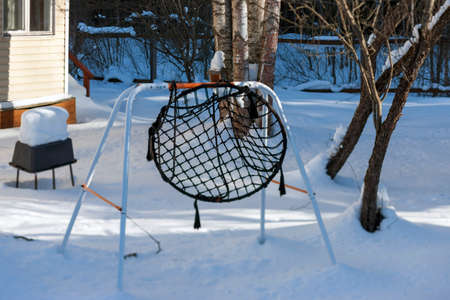 Snowy garden with abandoned hummock, sunny daylight imageの写真素材