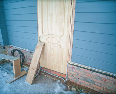 door propped up shut by a board, outdoor shotの写真素材