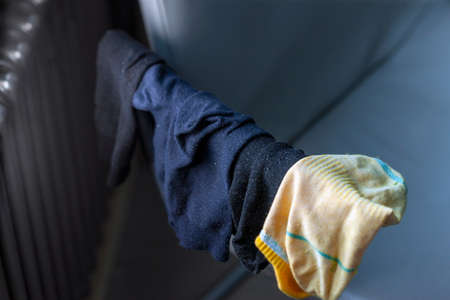 collection of washed socks drying on a chair handle next to a radiator, indoor closeup