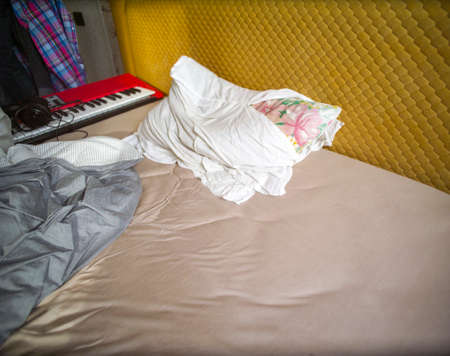 Musician bedroom with a synthesizer on unmade bedの写真素材