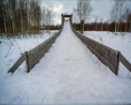 abandoned ice slide with partly melted snow, early spring landscapeの写真素材