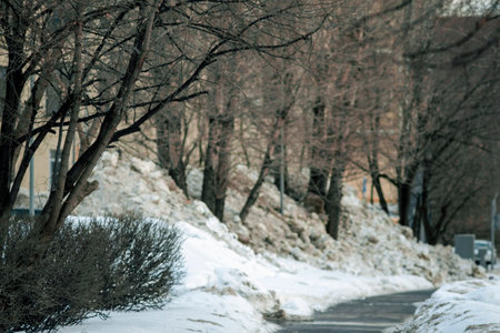 the piles of melting dirty snow on the street, urban scene, the focus in the foregroundの写真素材