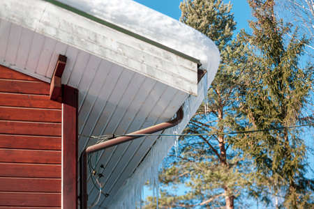 outdoor shot of a modern wooden house rooftop with iciclesの写真素材
