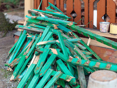 painted cut fence sections about to be used like a firewood, outdoor shot, concept of survival